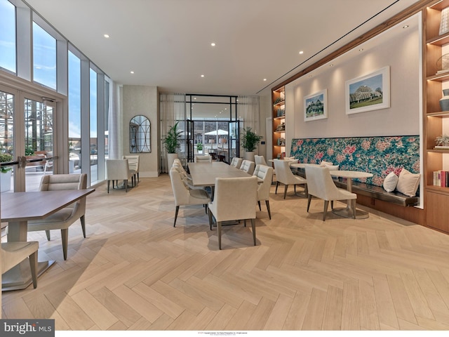 interior space with floor to ceiling windows, french doors, light parquet floors, and built in shelves