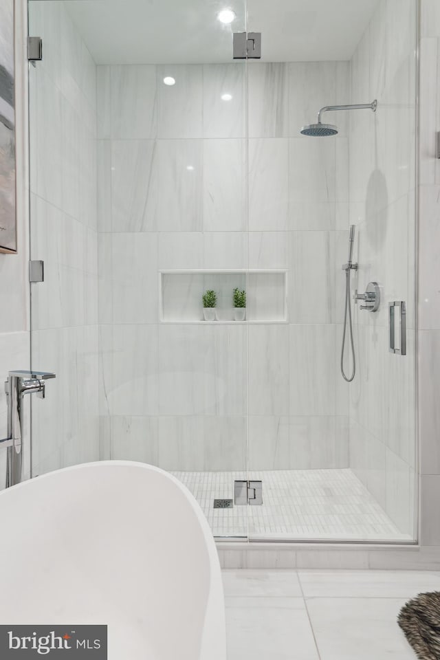 full bathroom with a soaking tub and a shower stall