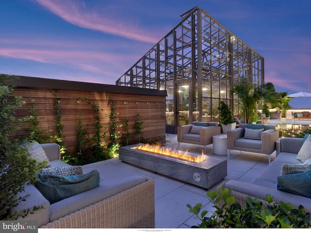 patio terrace at dusk with an outdoor living space with a fire pit