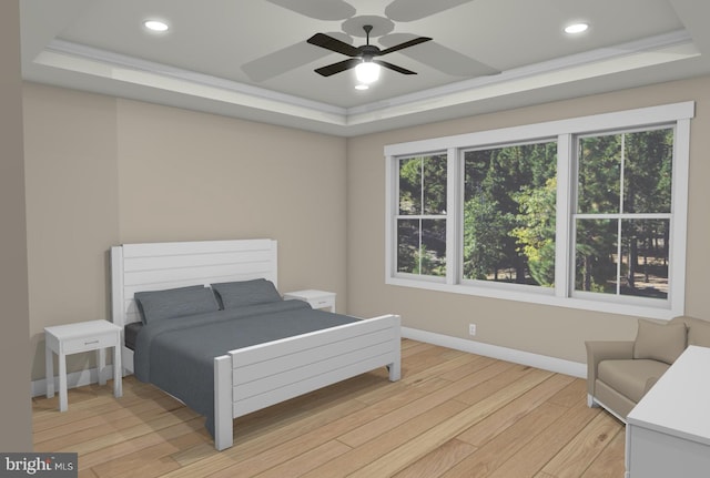 bedroom featuring light hardwood / wood-style flooring, ceiling fan, and a tray ceiling