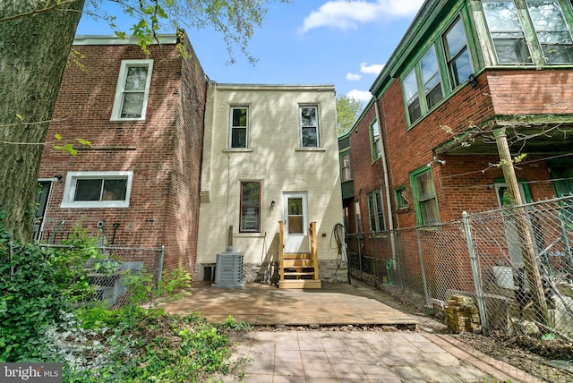 rear view of property with central air condition unit and a patio