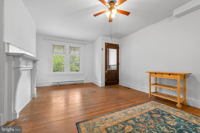 interior space featuring wood-type flooring, ceiling fan, and a baseboard heating unit