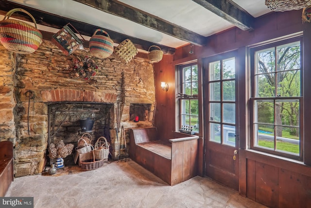 unfurnished room with a healthy amount of sunlight and beam ceiling