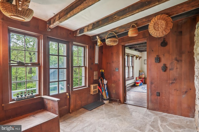 interior space with beamed ceiling, plenty of natural light, wooden walls, and a wall unit AC