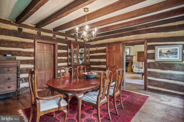 dining area with rustic walls, wood-type flooring, and beam ceiling