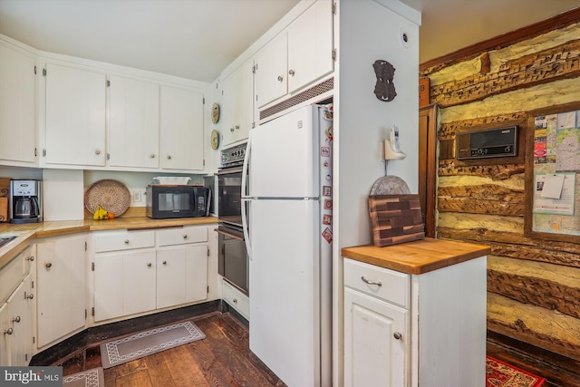 kitchen featuring white fridge, dark hardwood / wood-style floors, and white cabinetry