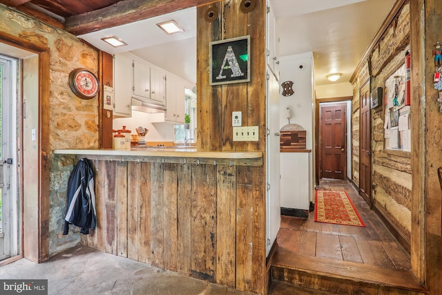 kitchen featuring hardwood / wood-style flooring, custom exhaust hood, and beam ceiling