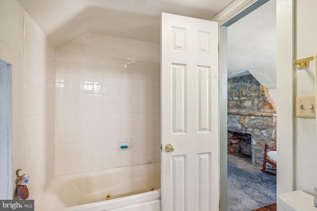 bathroom featuring toilet and tiled shower / bath