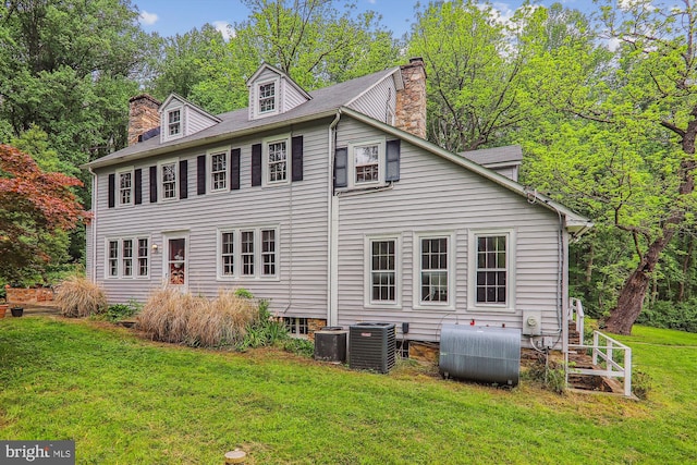 rear view of property featuring a yard and central AC