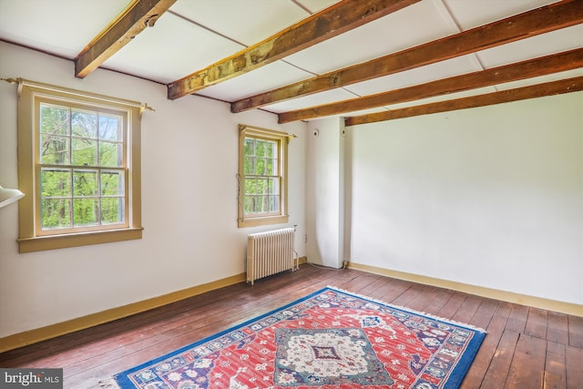 spare room featuring beamed ceiling, hardwood / wood-style floors, and radiator