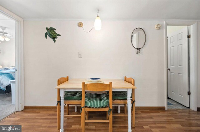 dining area featuring ornamental molding, baseboards, and wood finished floors