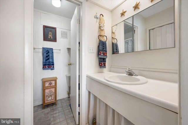 bathroom featuring vanity, toilet, and visible vents