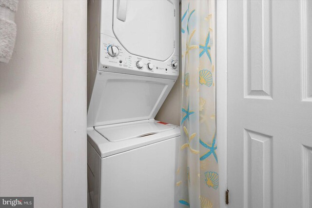 clothes washing area featuring laundry area and stacked washer / dryer