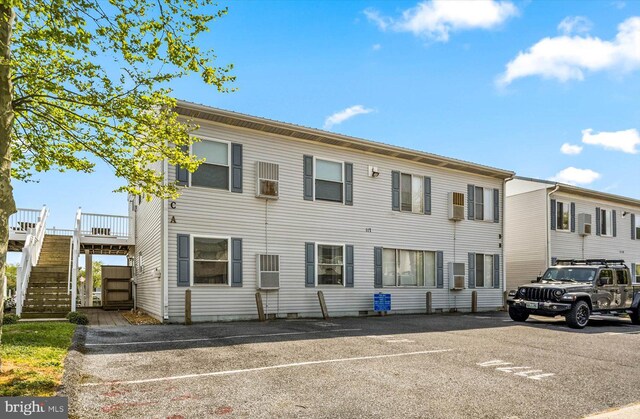 view of front of home featuring stairway and uncovered parking