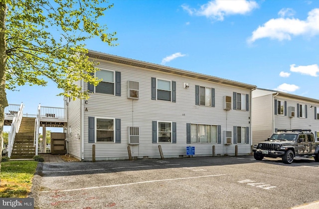 view of front of home featuring stairway and uncovered parking