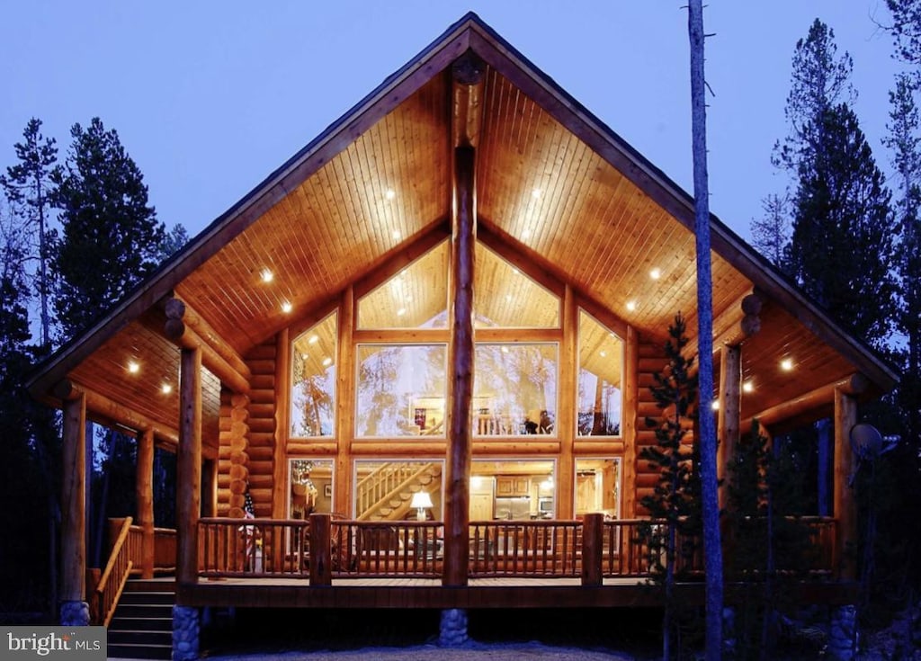 back house at dusk featuring a porch