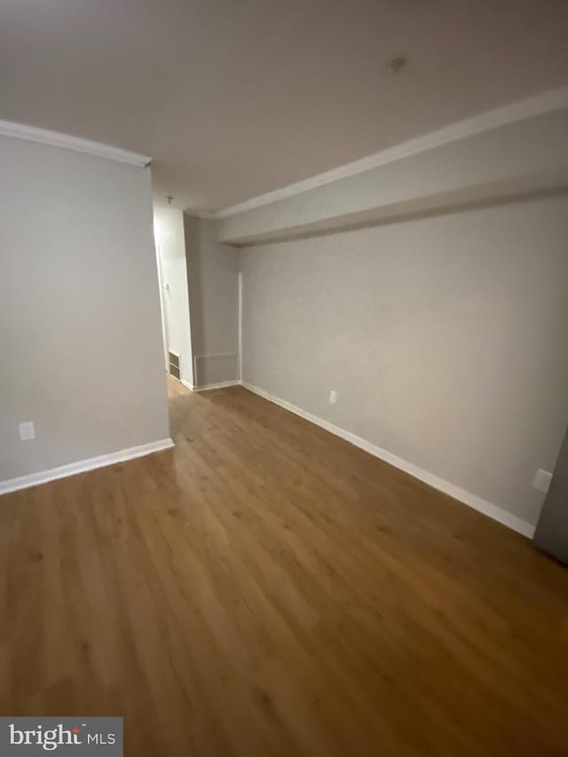 spare room with crown molding and hardwood / wood-style flooring