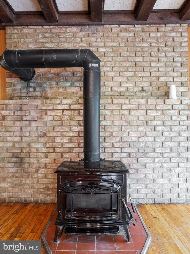 interior details with hardwood / wood-style flooring and a wood stove