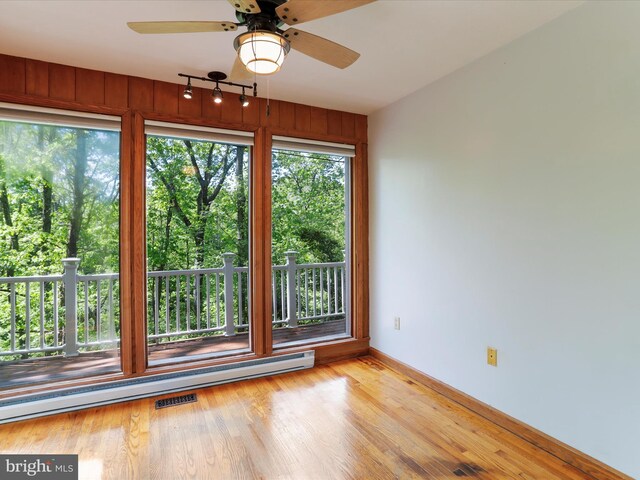 spare room featuring ceiling fan, a baseboard radiator, and light wood-type flooring