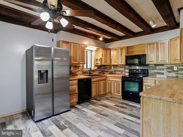 kitchen featuring wood counters, beamed ceiling, sink, backsplash, and black appliances