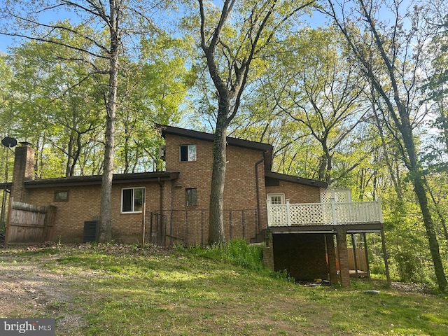 rear view of house with a yard and a deck