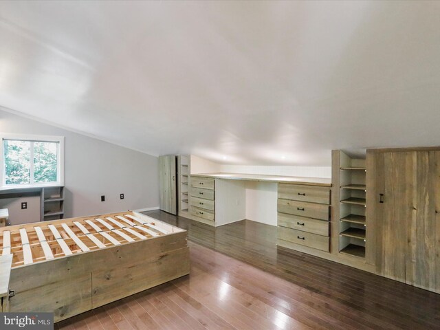 unfurnished bedroom featuring lofted ceiling and wood-type flooring