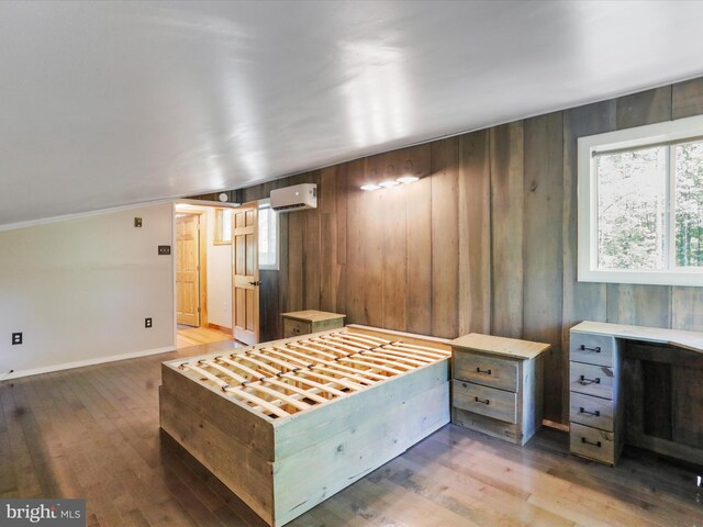 bedroom featuring hardwood / wood-style flooring, a wall mounted air conditioner, and wood walls