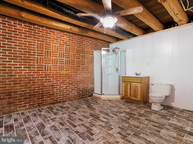 basement featuring hardwood / wood-style flooring, ceiling fan, brick wall, and sink