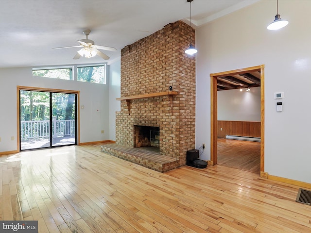 unfurnished living room with high vaulted ceiling, a fireplace, a baseboard radiator, ceiling fan, and light hardwood / wood-style flooring