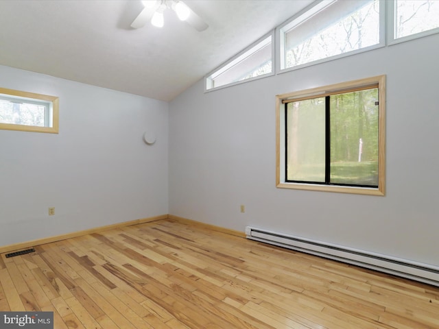 unfurnished room featuring vaulted ceiling, ceiling fan, light hardwood / wood-style floors, and a baseboard heating unit