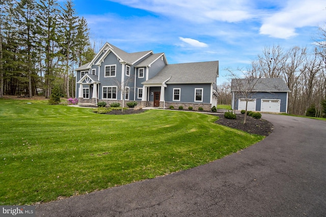 view of front of home featuring an outdoor structure, a garage, and a front yard