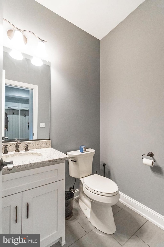 bathroom with oversized vanity, toilet, and tile flooring