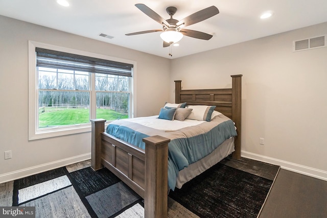 bedroom with dark hardwood / wood-style flooring and ceiling fan