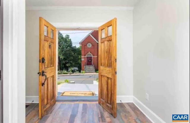 doorway featuring wood-type flooring and crown molding