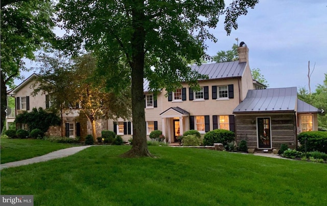 colonial inspired home featuring a front lawn