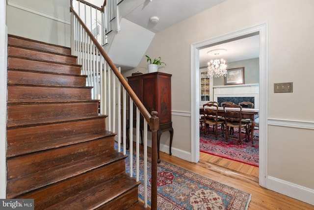 stairway featuring hardwood / wood-style floors and a chandelier