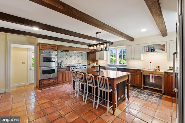 kitchen with decorative backsplash, beamed ceiling, and stainless steel appliances