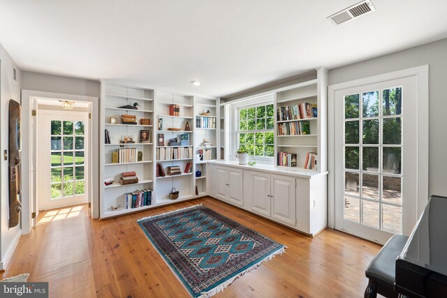 living area with a healthy amount of sunlight and light hardwood / wood-style flooring