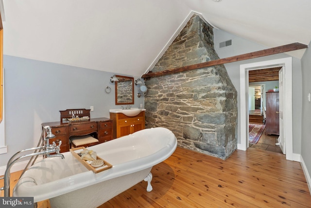 bathroom featuring vanity, lofted ceiling, and hardwood / wood-style flooring