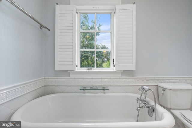 bathroom featuring a bath and toilet