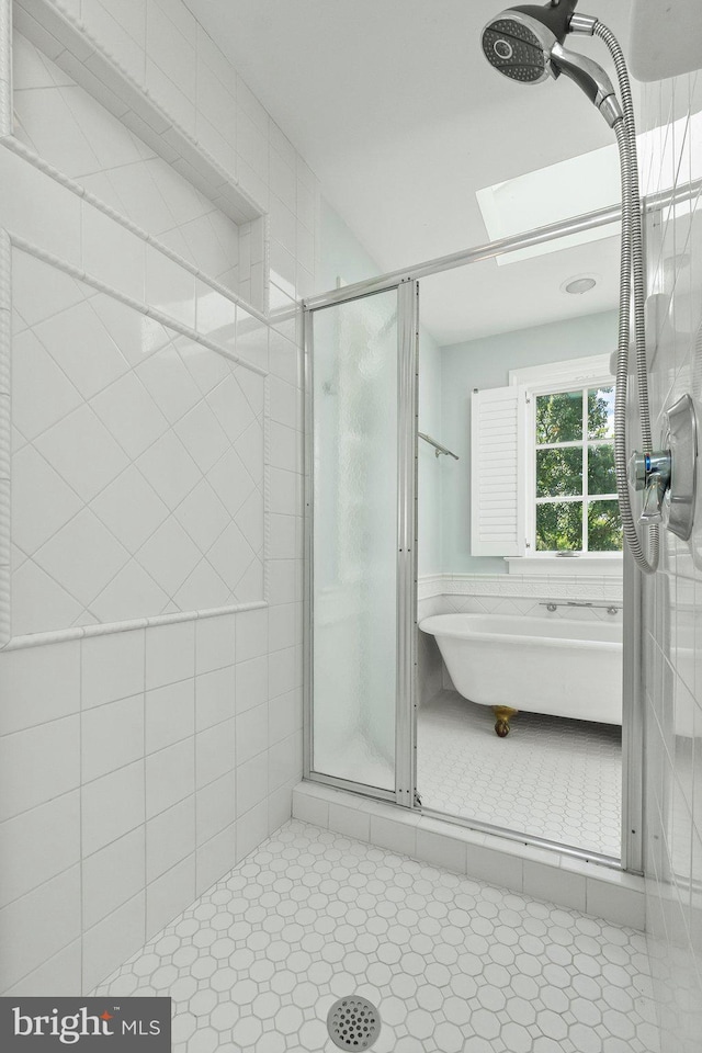 bathroom featuring a skylight and tiled shower