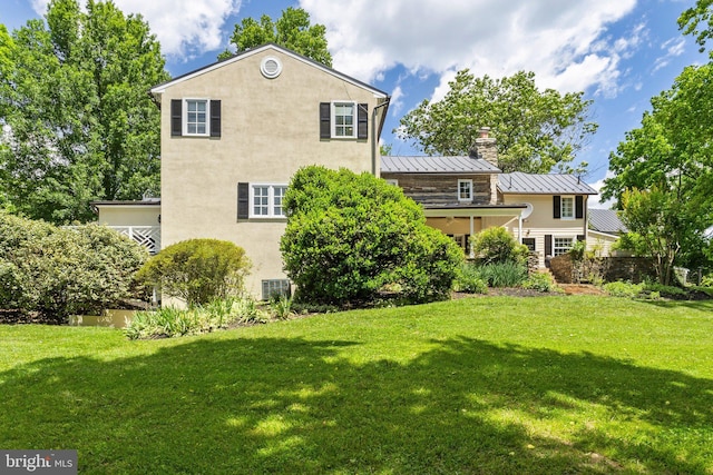 rear view of property with a lawn