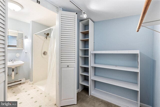 bathroom featuring baseboard heating and walk in shower