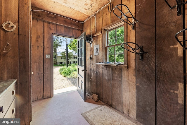 doorway with wooden walls and concrete flooring