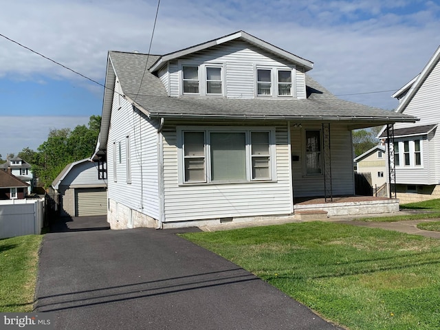 view of front facade featuring a front yard, an outbuilding, and a garage