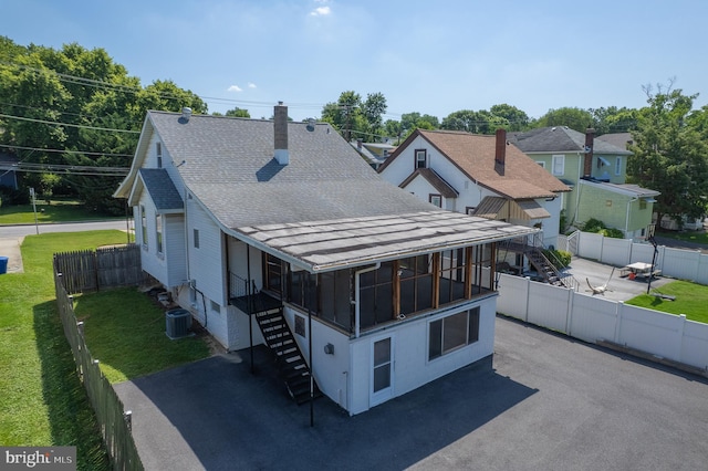 1722 Selma Ave, Halethorpe, MD 21227 - view of front of house with stairway, a shingled roof, a fenced backyard, and a chimney