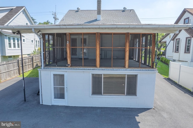 1722 Selma Ave, Halethorpe, MD 21227 - back of property with a sunroom, a shingled roof, and concrete block siding