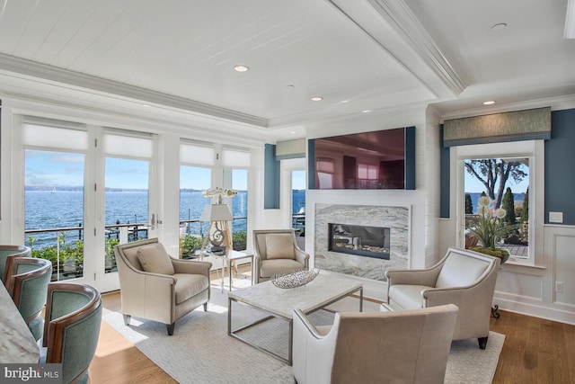 living room with hardwood / wood-style flooring, a high end fireplace, and crown molding