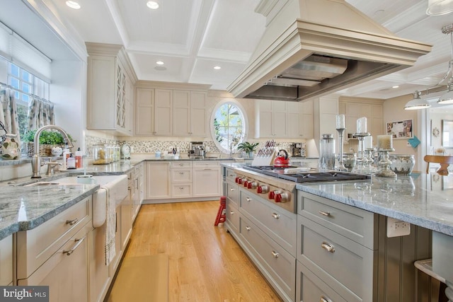 kitchen featuring light hardwood / wood-style floors, hanging light fixtures, stainless steel gas stovetop, beam ceiling, and coffered ceiling