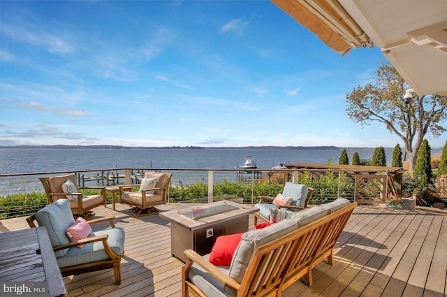 deck with a water view and an outdoor living space with a fire pit